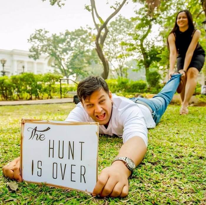 Funny wedding couple poses for photoshoot with hunt is finally over banner